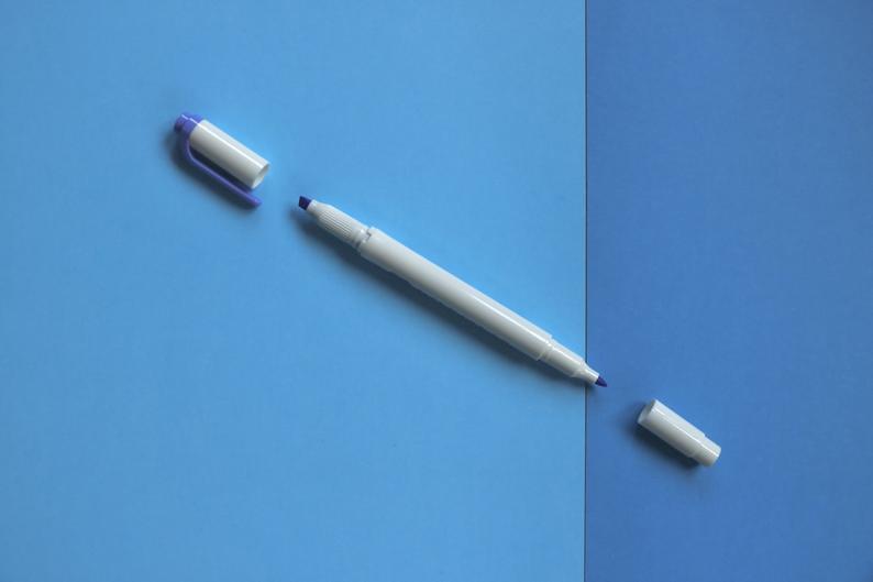 a zebra mildliner with both ends removed lying on a blue background