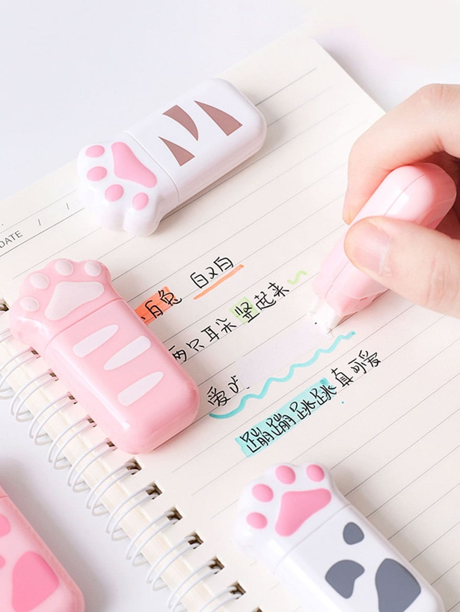 a pink cat paw correction tape being used to cover a writing pen mistake